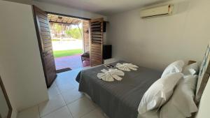 a bedroom with a bed with two flowers on it at Recanto da Praia Pousada in São Miguel do Gostoso