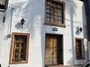 a white building with two doors and a lamp at Casa en tlaquepaque in Guadalajara
