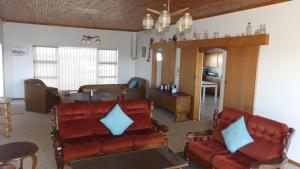 Una sala de estar con un sofá y sillas y una mesa. en Oyster Catcher Stay And Explore, en Cape St. Francis