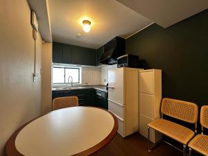 a small kitchen with a table and a refrigerator at 北渋谷inn in Tokyo