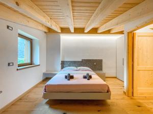 a bedroom with a bed and a wooden ceiling at Luxury Chalet Dolomiti-Campiglio-Trentino in Porte di Rendena