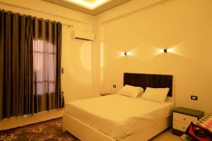 a bedroom with a white bed and a window at Tomorrow Land villa in Luxor