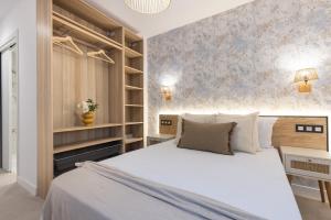 a bedroom with a large white bed and shelves at Villa MORERA in Vilaseca de Solcina