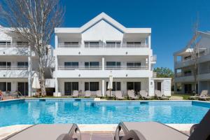 a swimming pool in front of a building at Duvabitat Apartments in Port de Pollensa
