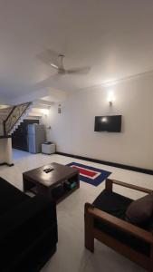 un soggiorno con un divano e una TV a parete di 2BHK Flat in Arpora, 10 mins from Baga Beach ad Arpora