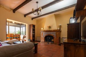 a living room with a couch and a fireplace at Finca Navalpino a 900 m de Puy du Fou in Guadamur