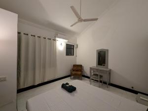 Camera bianca con ventilatore a soffitto e TV. di 2BHK Flat in Arpora, 10 mins from Baga Beach ad Arpora