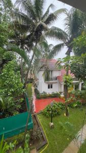 una casa con delle palme davanti di 2BHK Flat in Arpora, 10 mins from Baga Beach ad Arpora