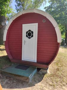 a red dog house with a door in it at TinyHouse "Comet" am See, an der Mecklenburger Seenplatte in Fürstenberg-Havel