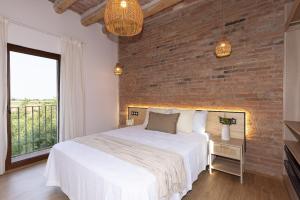 a bedroom with a white bed and a brick wall at Villa MORERA in Vilaseca de Solcina +55 photos