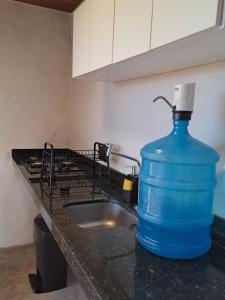 a large blue water bottle sitting on a kitchen counter at Casa Vento - 2 Andares e Cozinha in Luis Correia