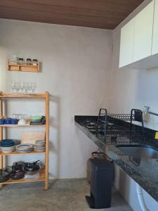 a kitchen with a sink and a shelf with dishes at Casa Vento - 2 Andares e Cozinha in Luis Correia +19 photos