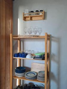 a shelf with plates and glasses on it at Casa Vento - 2 Andares e Cozinha in Luis Correia