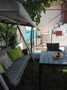 a gazebo with a couch and a table with a laptop at Apartment Vrančić in Šibenik