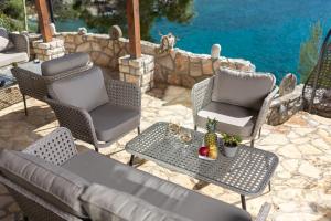 a patio with chairs and a table with a pineapple on it at Villa Jagodna in Hvar