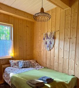 a bedroom with a bed in a wooden wall at Leśne zacisze nad Narwią in Ostrykół Włościański