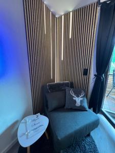 a room with a blue chair and a table at Exklusive FeWo AllgäuStern Steibis mit WLAN Sauna Kamin und Oberstaufen PLUS Card mit SKIPASS in Oberstaufen