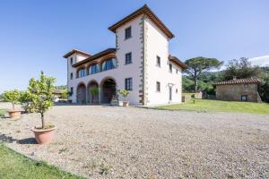 una gran casa blanca con un árbol en la entrada en Villa Casaforte, en Loro Ciuffenna