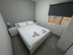 a bedroom with a bed with white shoes on it at Apartamentos en la rambla in Sant Feliu de Guixols
