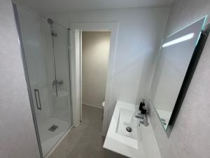 a white bathroom with a shower and a sink at Apartamentos en la rambla in Sant Feliu de Guíxols