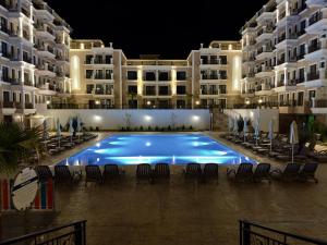 a swimming pool in front of a building at night at Apartment Summer Vibes in Sveti Vlas