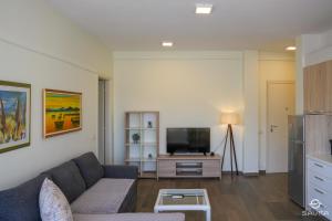 a living room with a couch and a flat screen tv at Gjiri i Lalzit - Savita Apartments - Kompleksi Turistik Lura 2 in Mullini i Danit