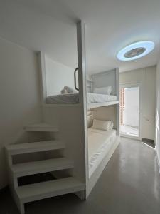 a white room with bunk beds and a frisbee at Apartamentos en la rambla in Sant Feliu de Guíxols