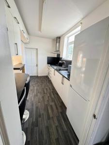 a kitchen with a white refrigerator and a sink at Bright & Cozy Private Room Near Bristol City Centre in Bristol