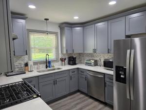 a kitchen with white cabinets and stainless steel appliances at 3BR Home Best of Both-FIFA World Cup-Truist Park in Smyrna