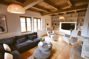 a living room with a black couch and a fireplace at DOM POD STRZECHĄ, NAD RZEKĄ - 200m2 in Swornegacie