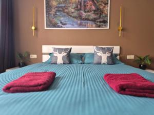 a bed with two red pillows on top of it at OTILIA apartment in Zell am See