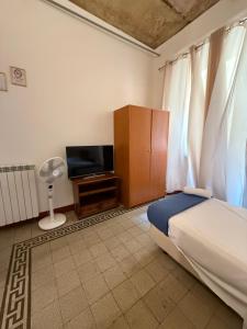a bedroom with a bed and a flat screen tv at Soggiorno Emanuela in Rome