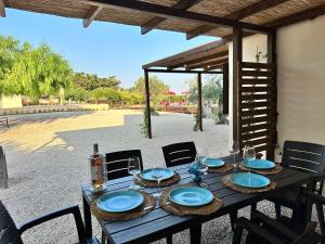 a wooden table with blue plates and glasses on it at B&B Villa Jonica in Gallipoli