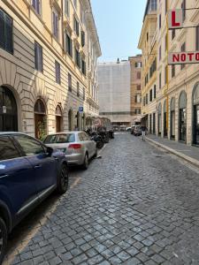 a cobblestone street with parked cars in a city at Soggiorno Emanuela in Rome +15 photos