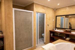 a bathroom with a tub and a toilet and a sink at Franskraal Bed and Breakfast Pty Ltd in Franskraalstrand