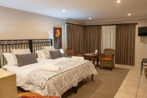 a bedroom with two beds and a table and chairs at Franskraal Bed and Breakfast Pty Ltd in Franskraalstrand