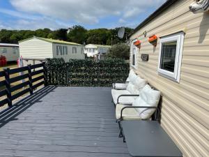 a row of chairs lined up against a building at Tingdene caravan park in Gunton