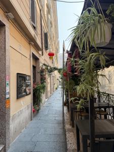 a narrow street with tables and chairs and plants at Soggiorno Emanuela in Rome