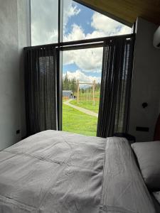a bedroom with a bed and a large window at The Prut Lodge in Vorokhta
