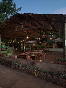 an outdoor patio with tables and chairs and flowers at Mundial Chalés e Ecoturismo in Delfinópolis