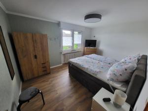 a small bedroom with a bed and a window at Ferienwohnung Am Brombachtal in Simmerath