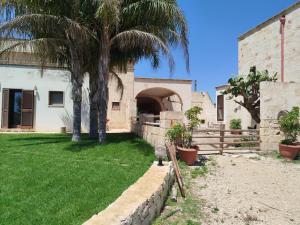 a house with a palm tree in a yard at B&B La Cupa in Torre Santa Susanna