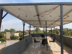 eine Terrasse mit Tisch und Stühlen auf einem Dach in der Unterkunft Torobali IMMO Apartment 4- Modern 1BDR- Near Embassies and Restaurants- Secure Building in Bamako