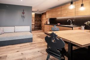 a kitchen and living room with a table and a couch at Appartement- und Wellnesshotel Winkler in Falzes