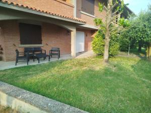 a patio with a table and benches in a yard at Casa Eben-Haezer in Fiumana