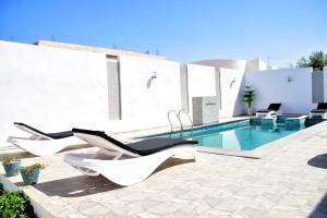 a patio with chairs and a swimming pool at Villa Sofia Djerba in Awlād ‘Umar