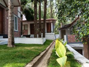a house with a yard with grass and trees at Alpine Cloud Resort in Yercaud