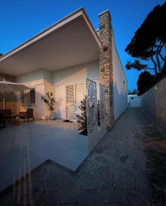 a white house with a patio in the evening at Le2Suites in Torre dell'Orso