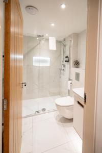 a white bathroom with a shower and a toilet at Town Center Duplex 6 in Harrogate +7 photos