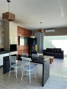 a kitchen with a table and chairs and a couch at A Casa Paradisiaca l Luxo Piscina Super Hiper Quente 60 Graus Aquecimento Elétrico e Piscina Enorme com Roupa de Cama e Banho in Caldas Novas +18 photos